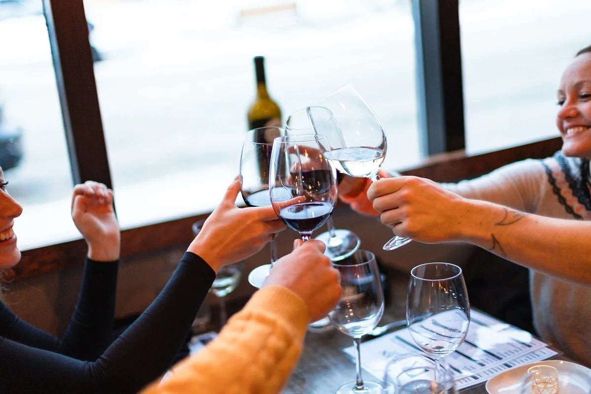 Guests toasting with drinks at The Raven Bistro